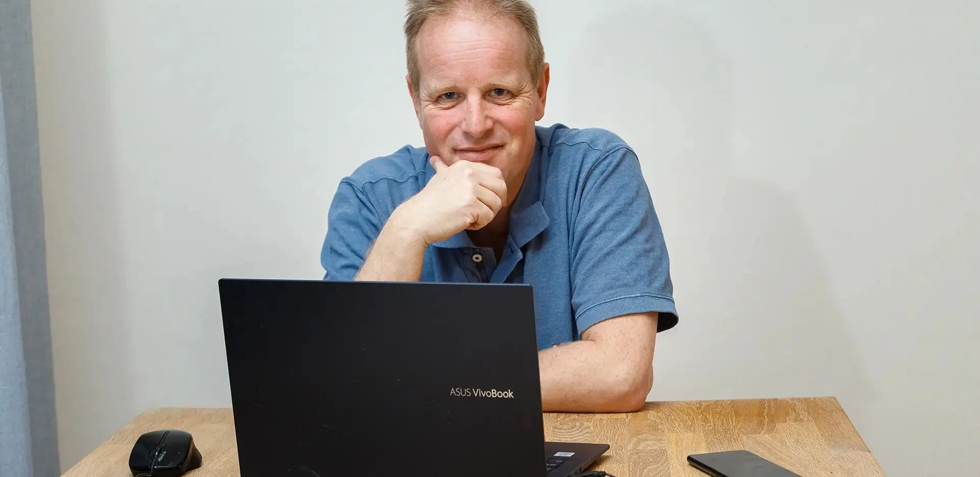 Maurice Yedema aan zijn bureau met laptop en telefoon