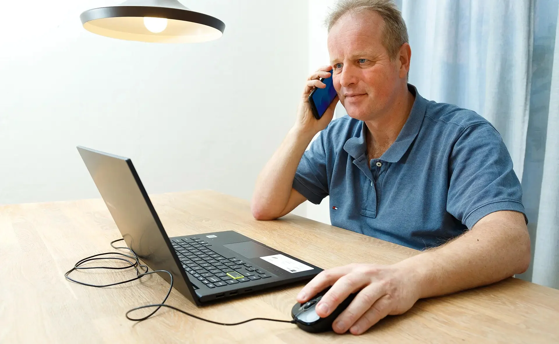 Maurice Yedema belt een klant vanachter zijn laptop